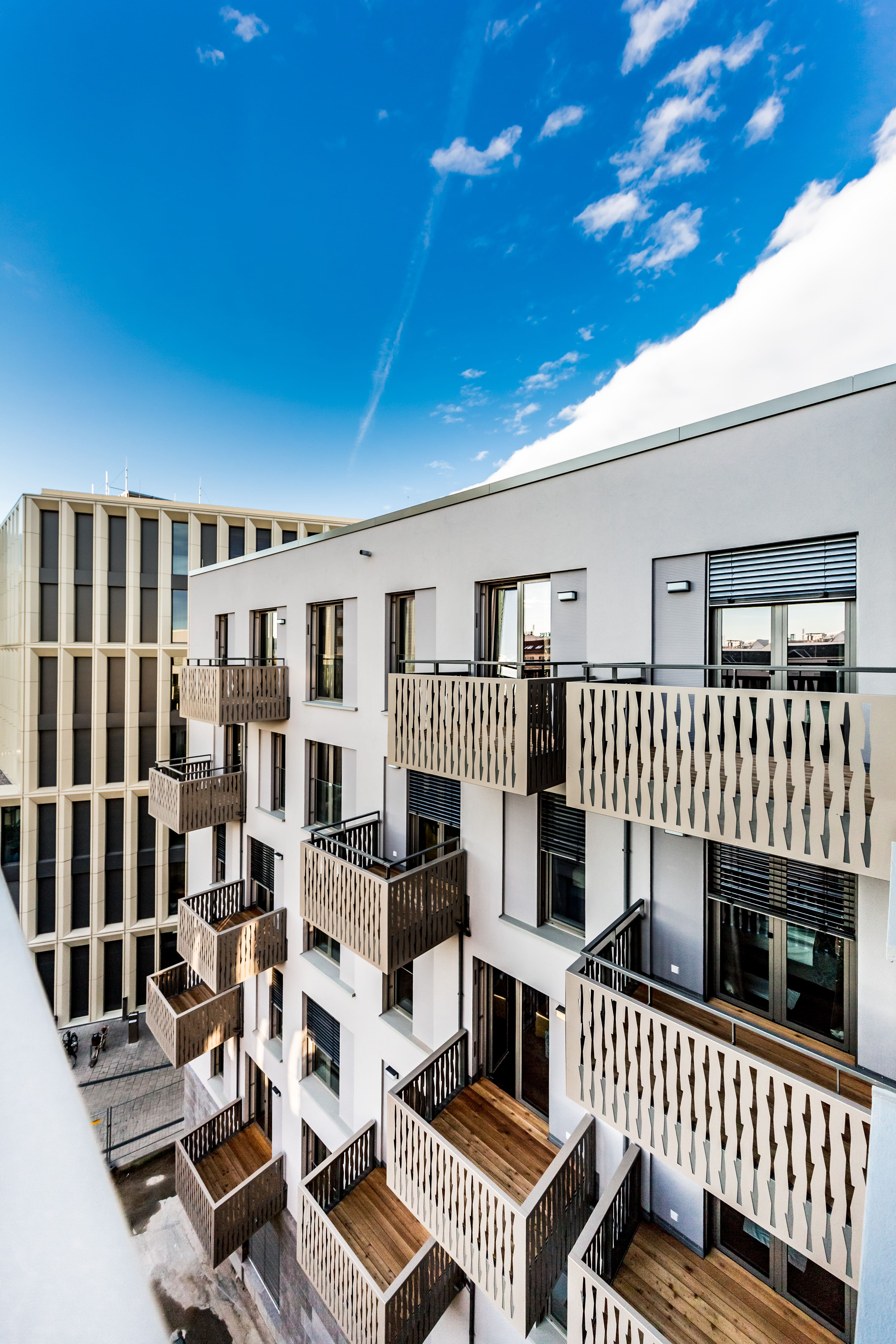 Einladendes Design für erholsame Aufenthalte Moderne Hotel-Fassade mit stilvollen Balkonen unter blauem Himmel