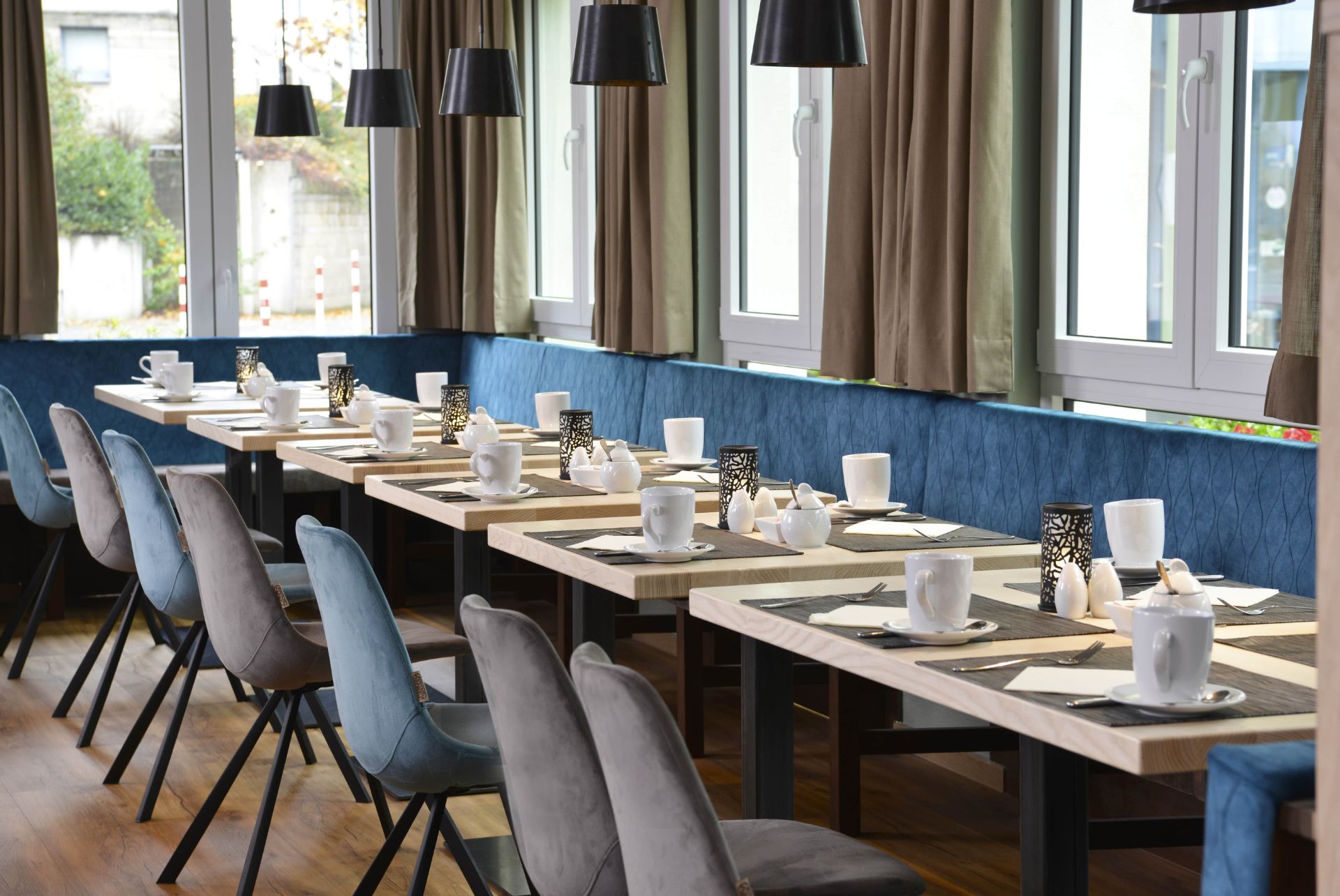 Genuss in stilvollem Ambiente – Ihr perfekter Start in den Tag Modern gedeckter Frühstücks- oder Tagungstisch in heller, einladender Atmosphäre mit stilvollen Sitzmöbeln
